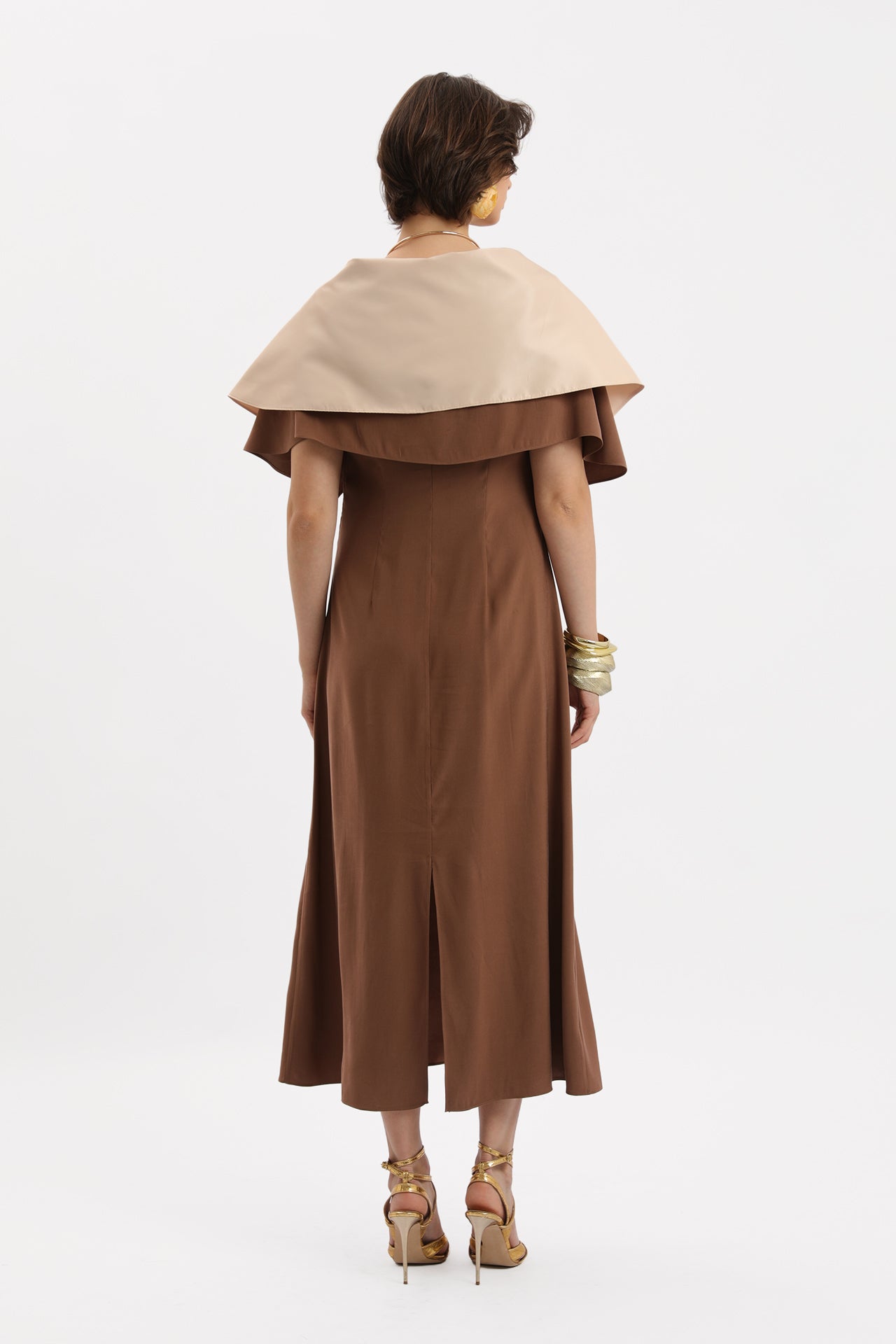 Coffee-colored midi dress with cape, brooch and tassel details.